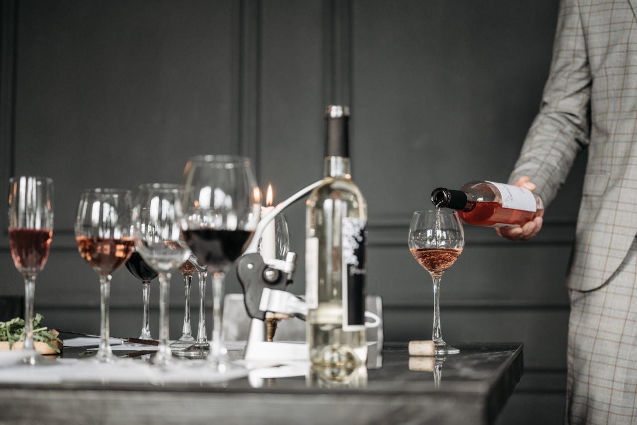 Close-up of a wine tasting session with a sommelier pouring rosé into a glass.
